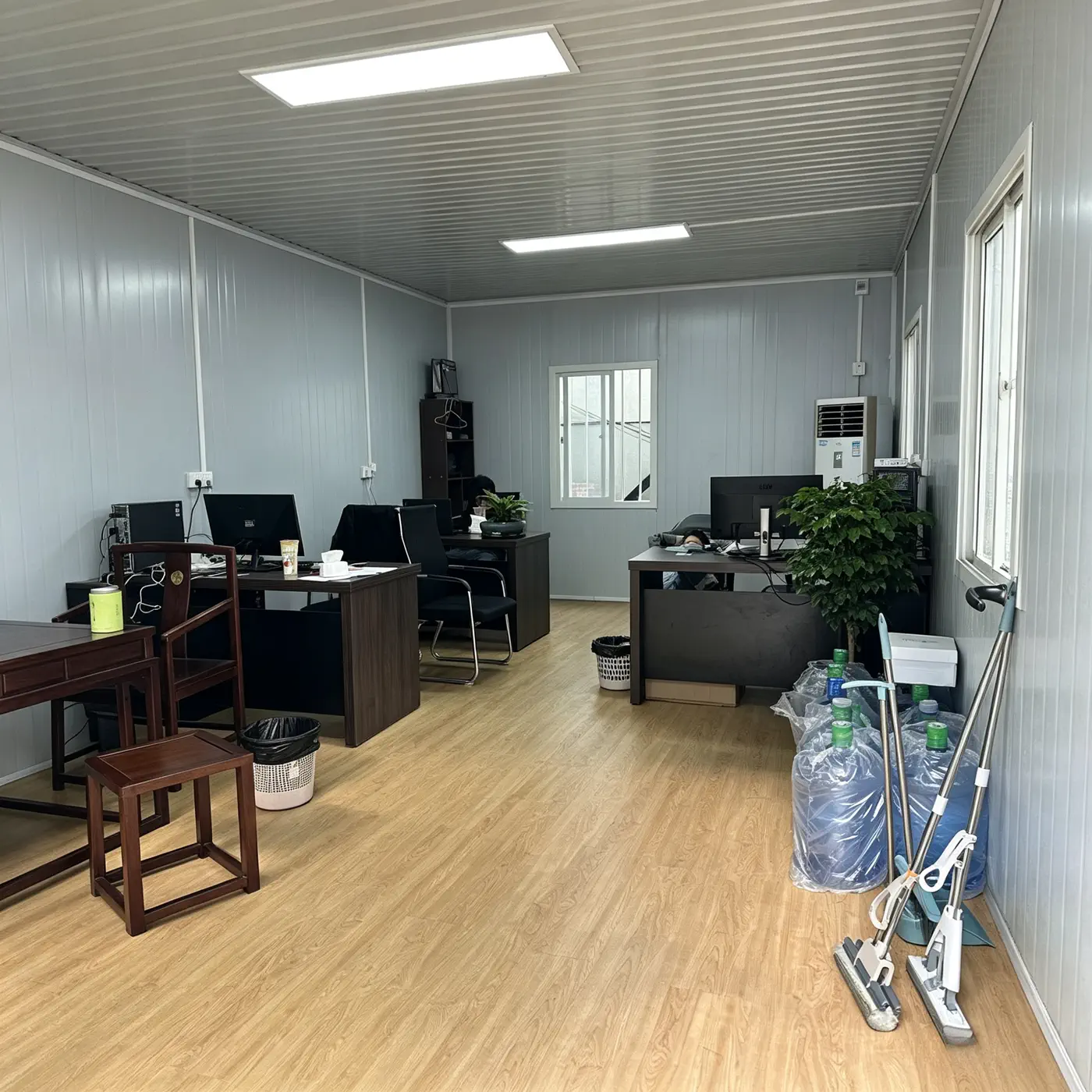 Compact modular office interior showing efficient desk storage and equipment layout